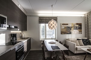Una cocina moderna con comedor, sofá y un amplio ventanal con persianas.