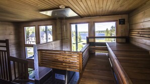 Una cabaña de madera con un banco, una mesa y vistas al exterior.
