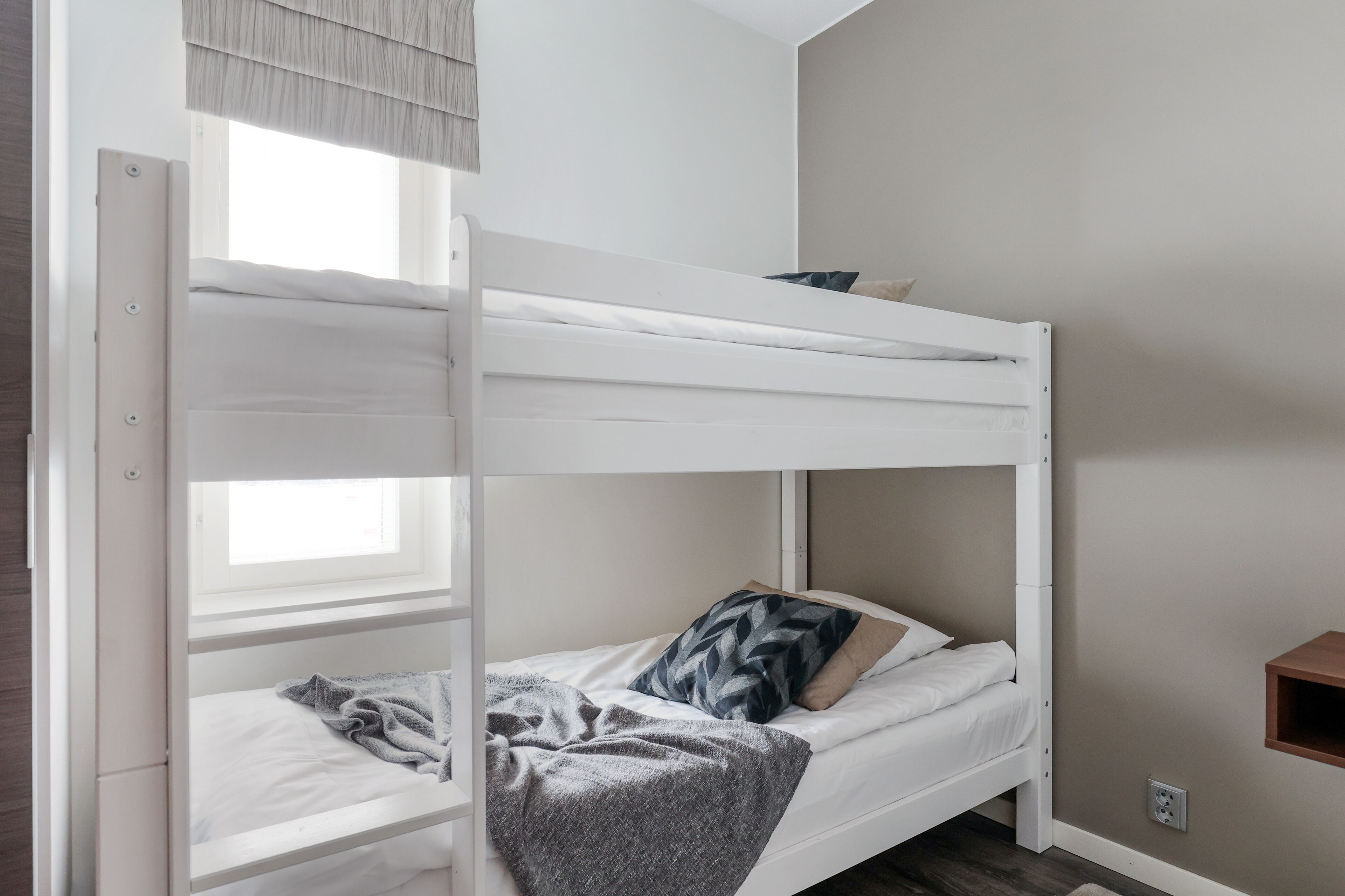 Una cama litera con una ventana sobre la cama superior.