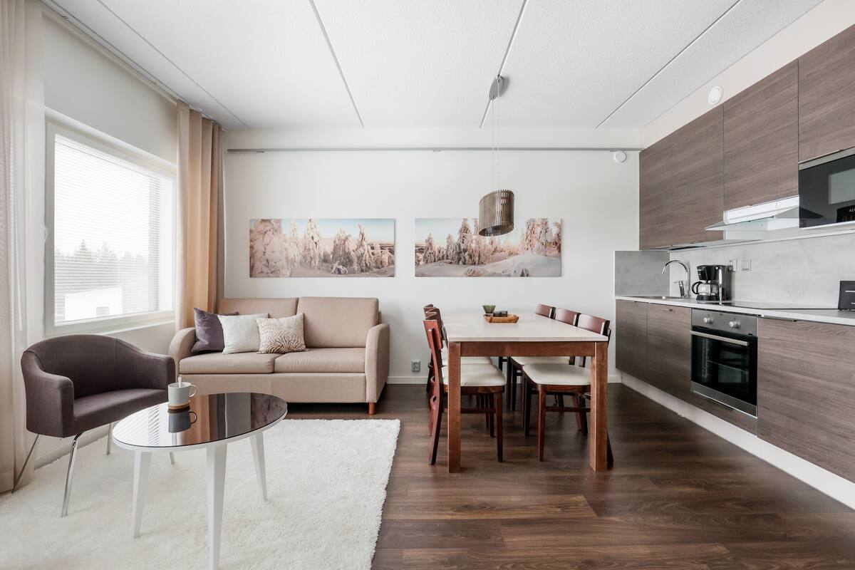 Una sala de estar moderna con sofá, mesa de centro y mesa de comedor.