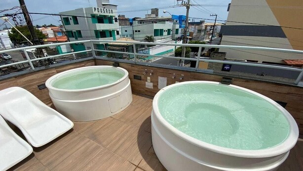 Een dak met twee whirlpools en een pooltafel.