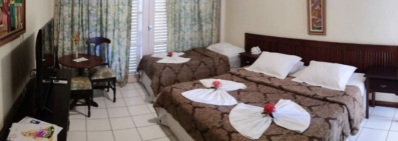 Una habitación de hotel con dos camas, un escritorio y una silla.
