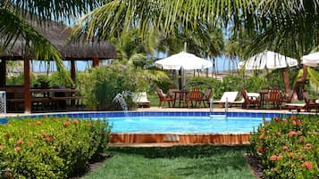 Una piscina al aire libre, sombrillas, sillones reclinables de piscina