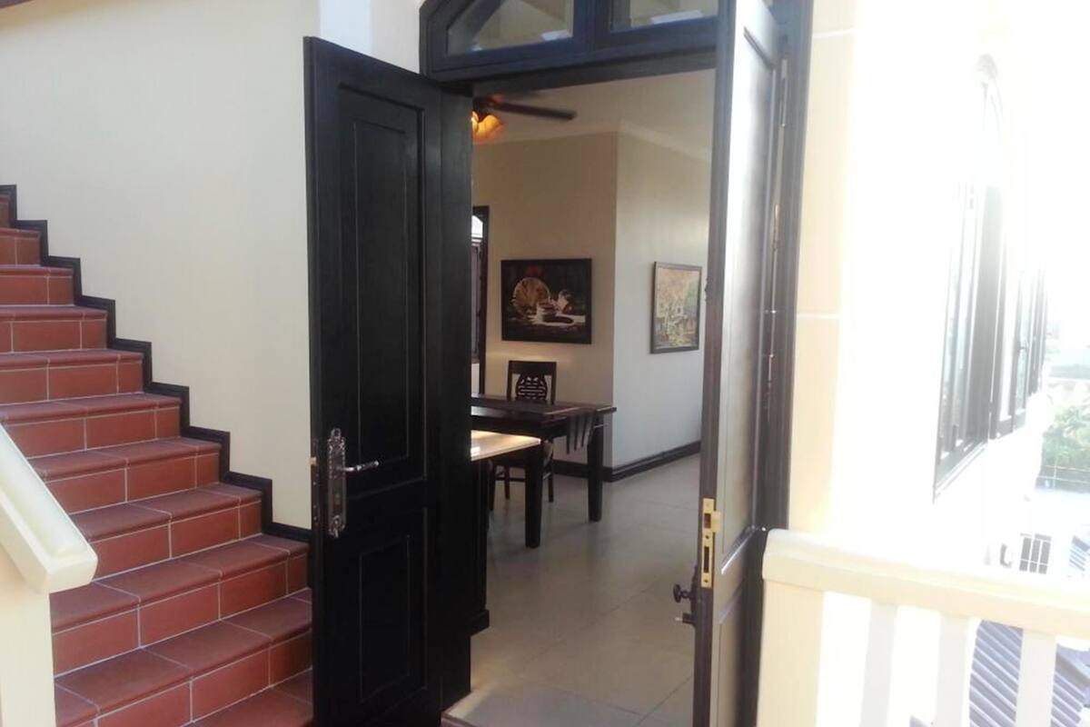 A staircase leading to a dining area with a table and chairs.