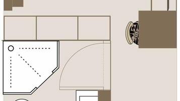 A floor plan of a hotel room with a bed, a desk, a chair, a wardrobe, and a bathroom.