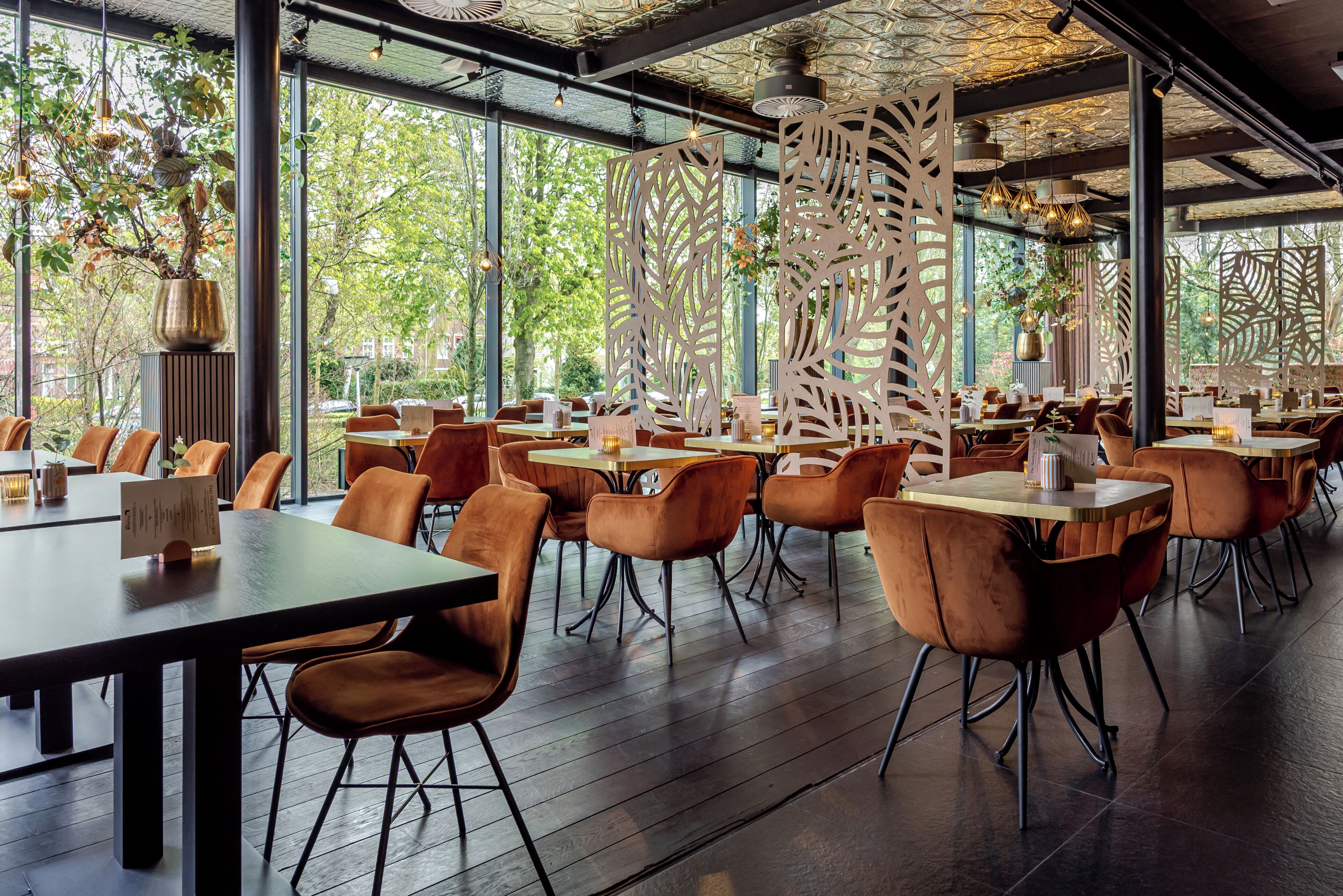 A spacious dining area with high ceilings, large windows, and modern furniture.