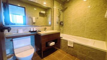 A bathroom with a toilet, sink, and shower.