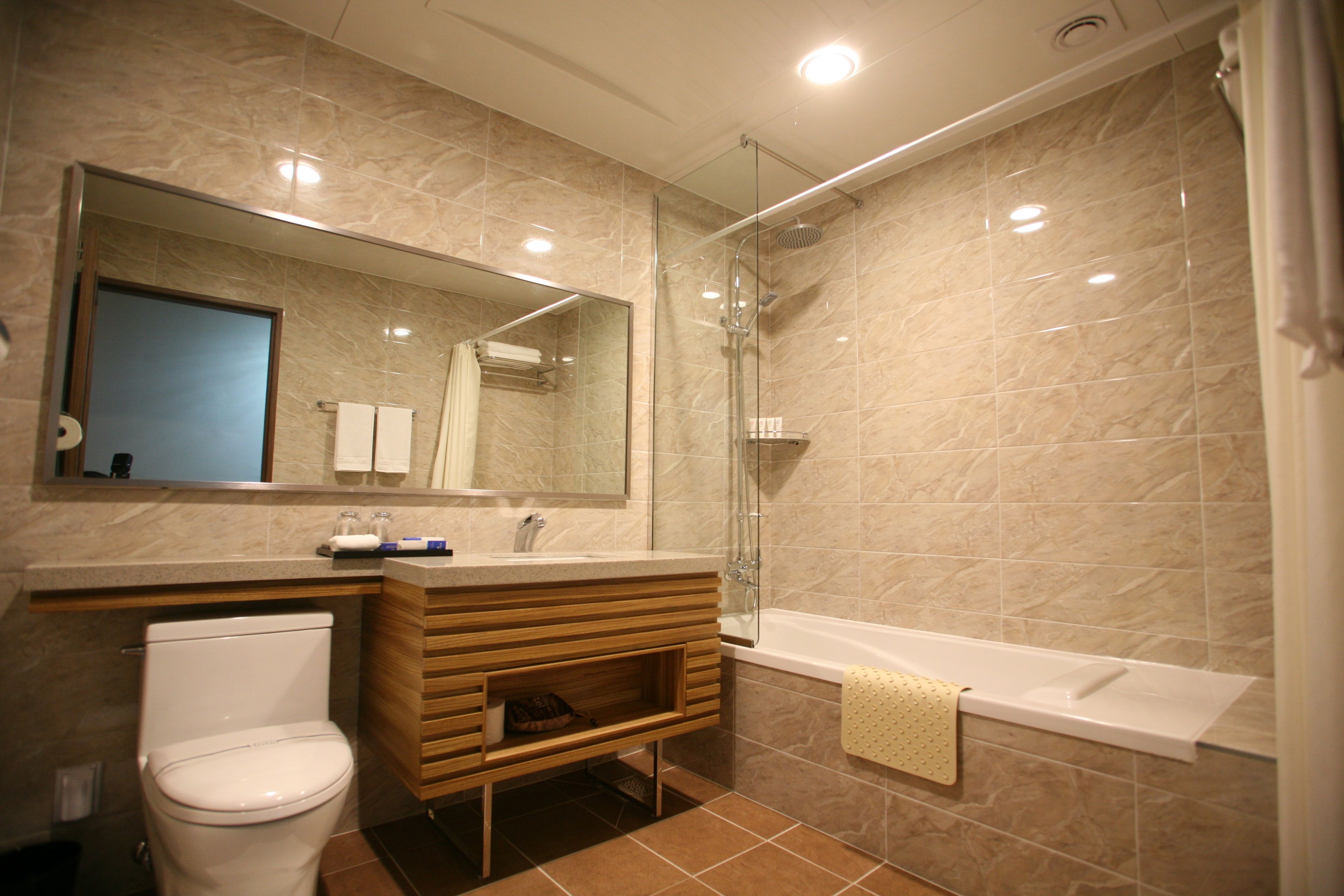 Un baño moderno con inodoro, tocador, lavabo y ducha.