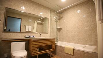 Un baño moderno con inodoro, tocador, lavabo y ducha.