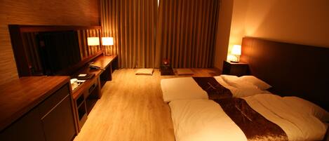 A hotel room with a large bed, bedside tables with lamps, a desk, and a mirror.