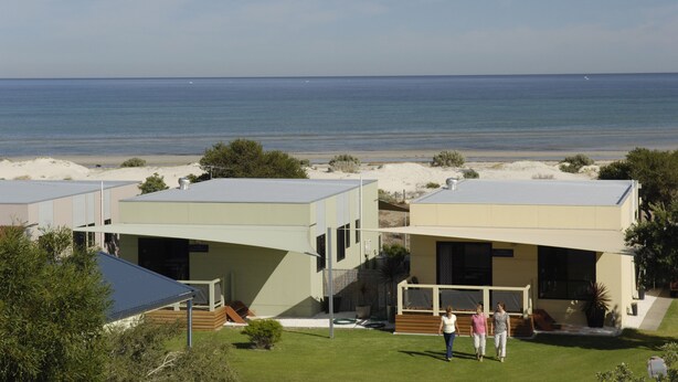 A modern resort with two-story buildings, a pool, and a view of the ocean. - Discovery Parks - Adelaide Beachfront (Semaphore Park)