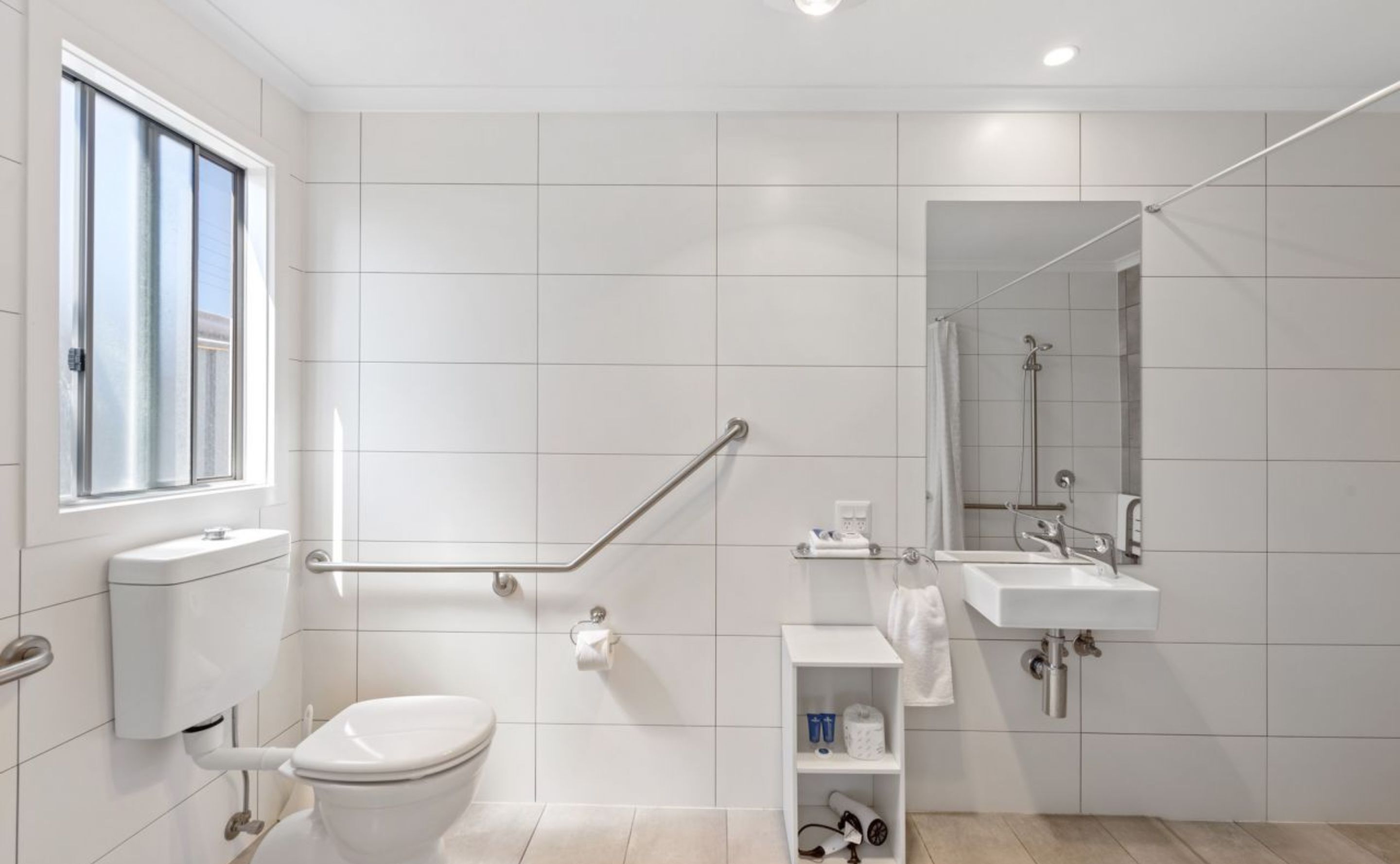 A modern bathroom with a toilet, bidet, shower, and sink.
