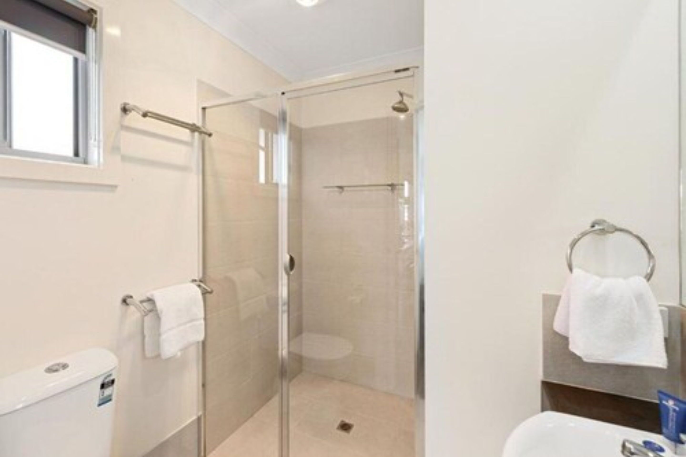 Une salle de bain moderne avec une douche à parois de verre, des toilettes et un lavabo.