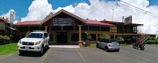 Un hôtel avec un toit rouge et une enseigne sur laquelle on peut lire : « El Guurrasco, hôtel-restaurant ».