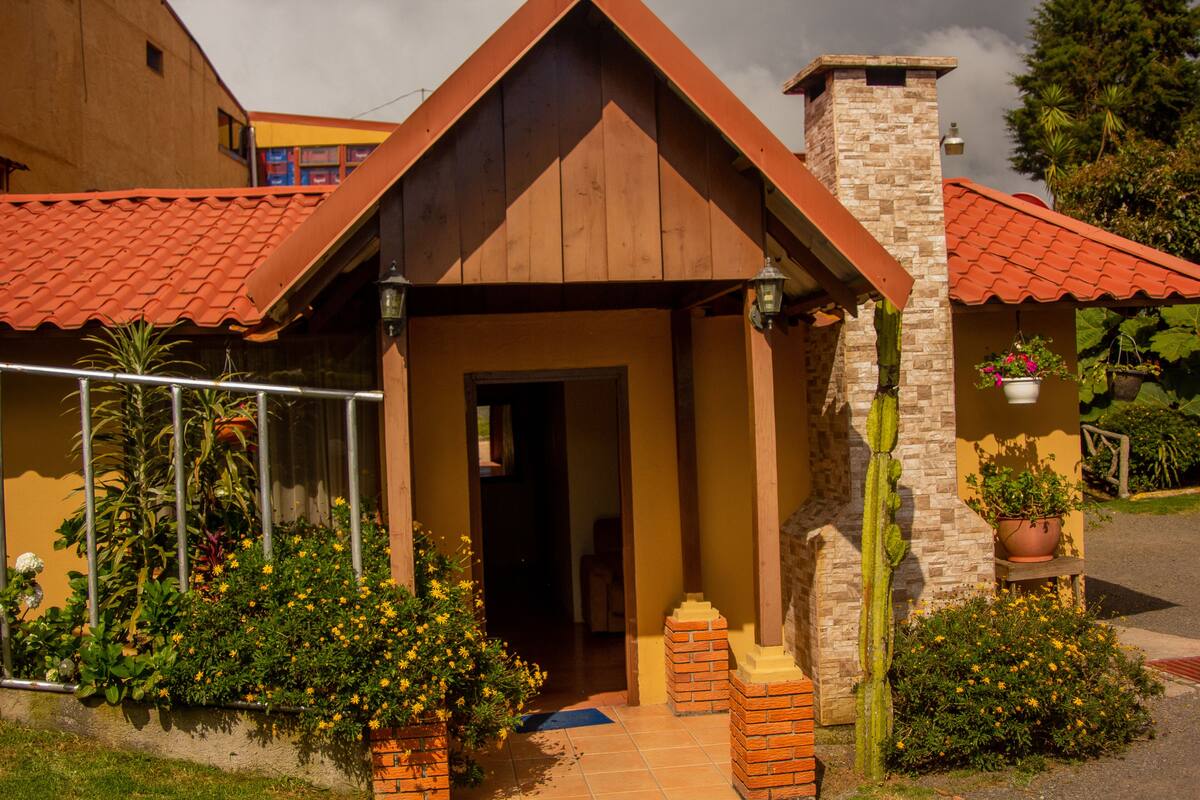 Ein Haus mit rotem Ziegeldach, einem Backsteinsschornstein und einer Haustür.
