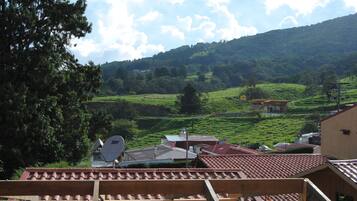 Vista de un valle verde con una casa y una antena parabólica en el tejado.