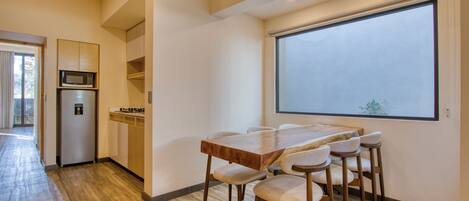 A modern kitchen with a microwave, refrigerator, and wooden cabinets.
