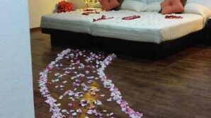 Un dormitorio con una cama, una mesita de noche, una lámpara y un cuadro en la pared.