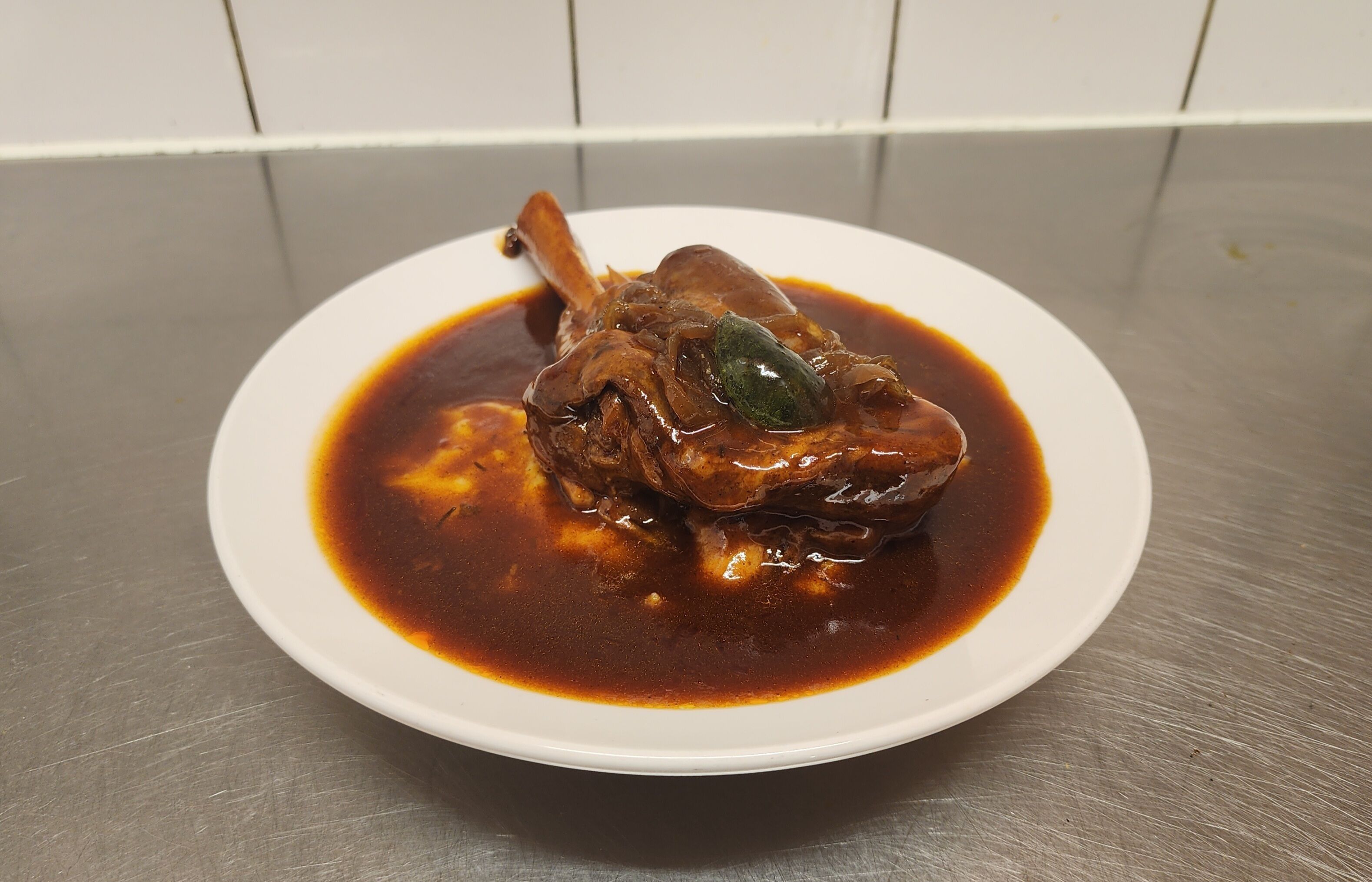Un plato de comida con un guiso de carne, servido en un plato blanco.
