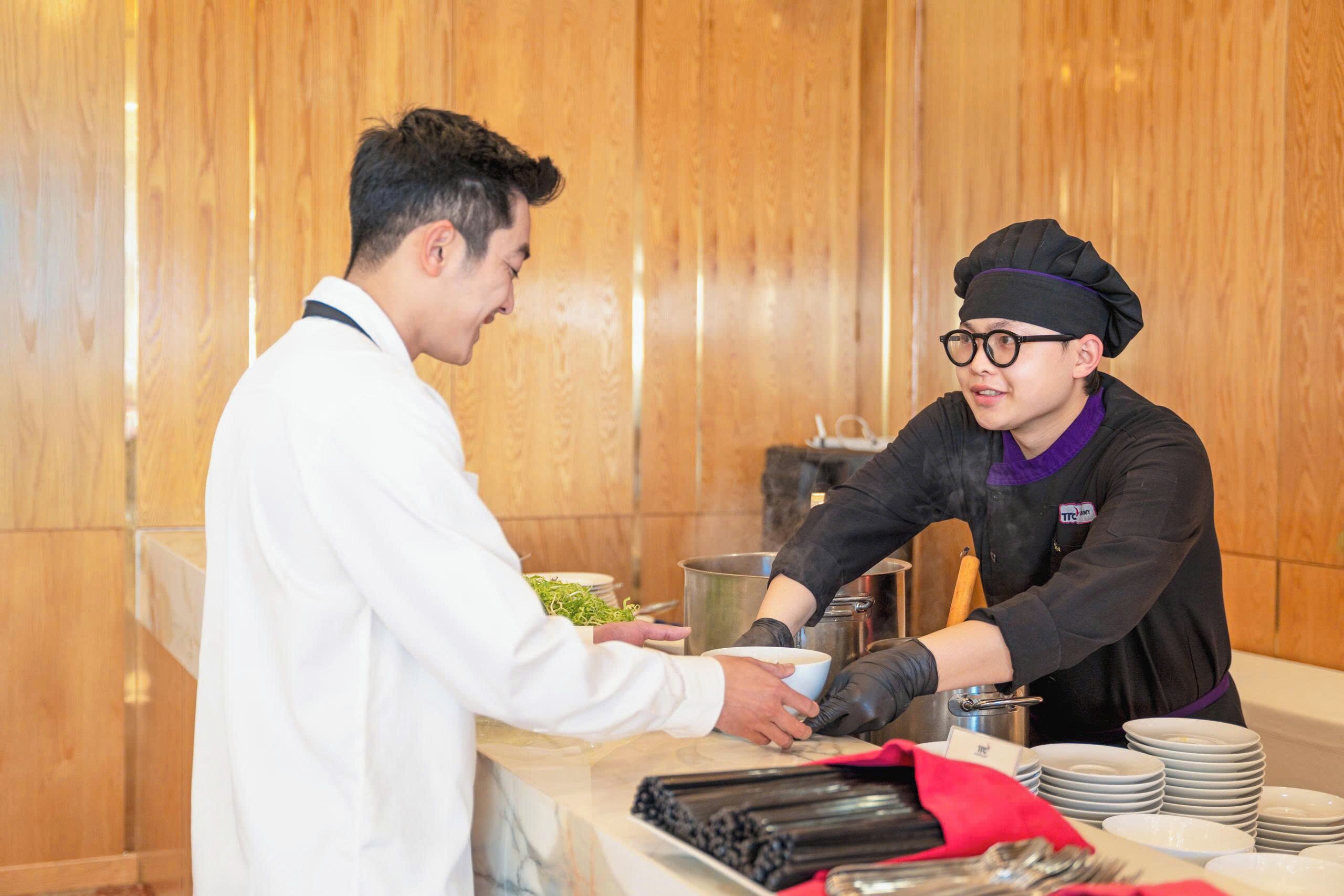 Un buffet où une personne sert de la nourriture à une autre.