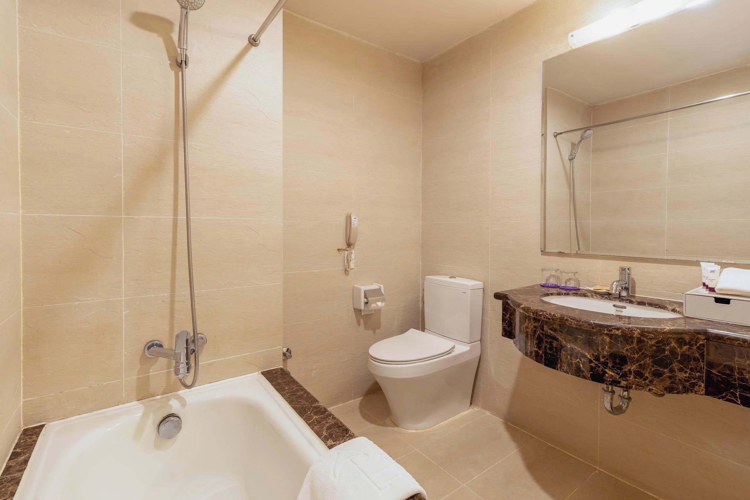 Een badkamer met een bad, toilet en wastafel.