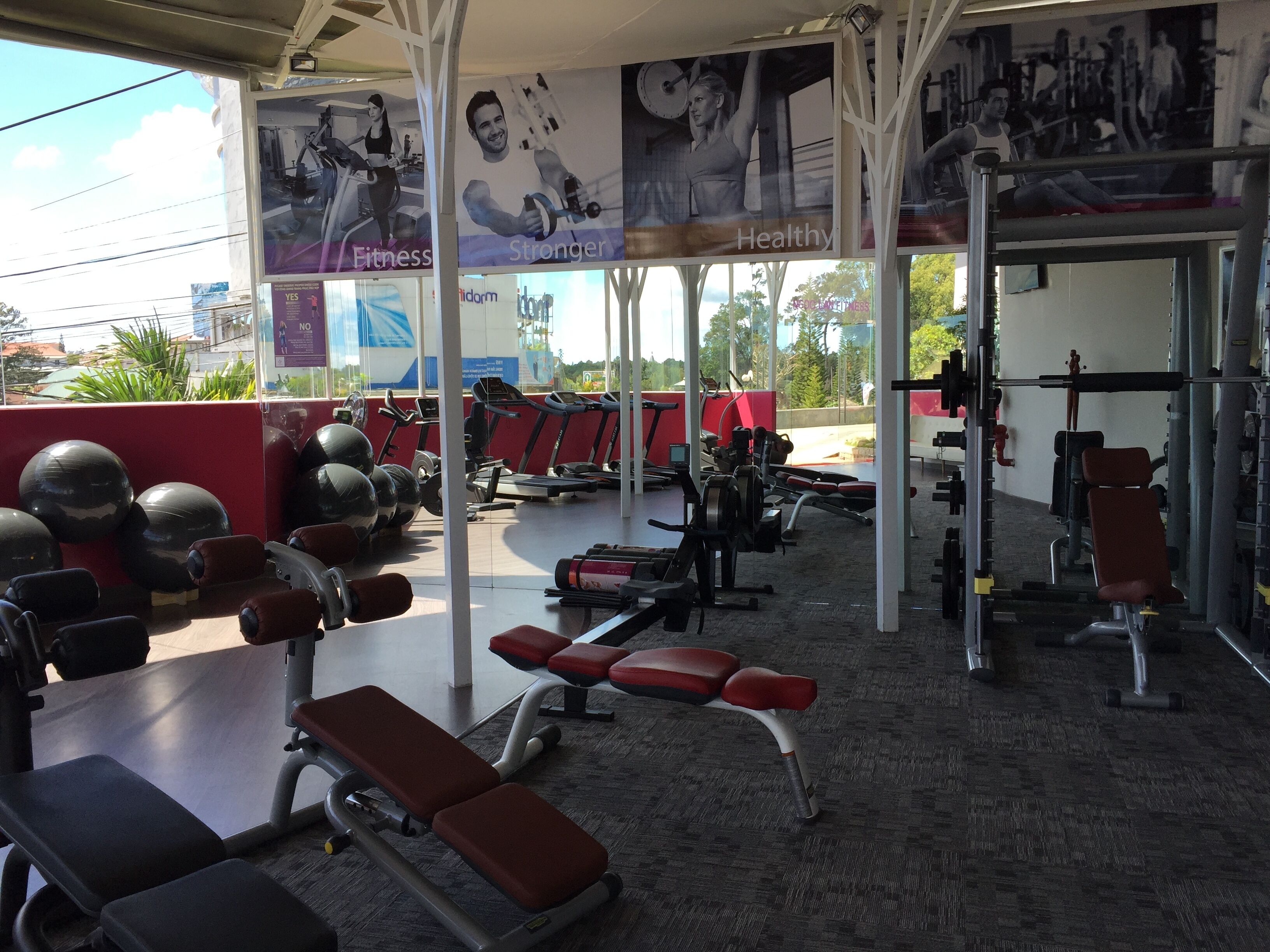 Een sportschool met trainingsapparatuur, banken en loopbanden.