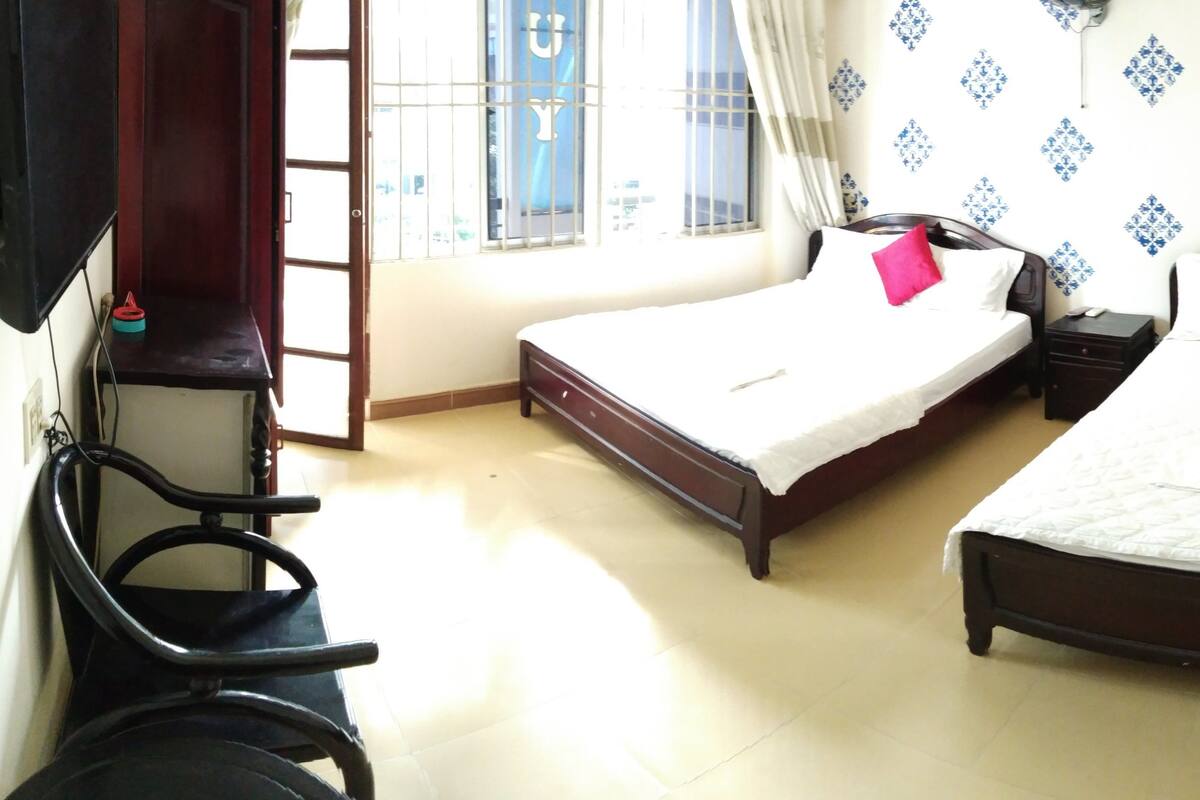 Une chambre d’hôtel avec deux lits, un bureau et une chaise.