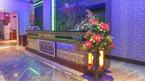 Un comptoir d’accueil avec une pancarte indiquant « SPA », un vase de fleurs et un sol carrelé.