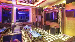 Une chambre luxueuse avec un sol à carreaux, un canapé moelleux, une table basse et un grand écran de télévision.