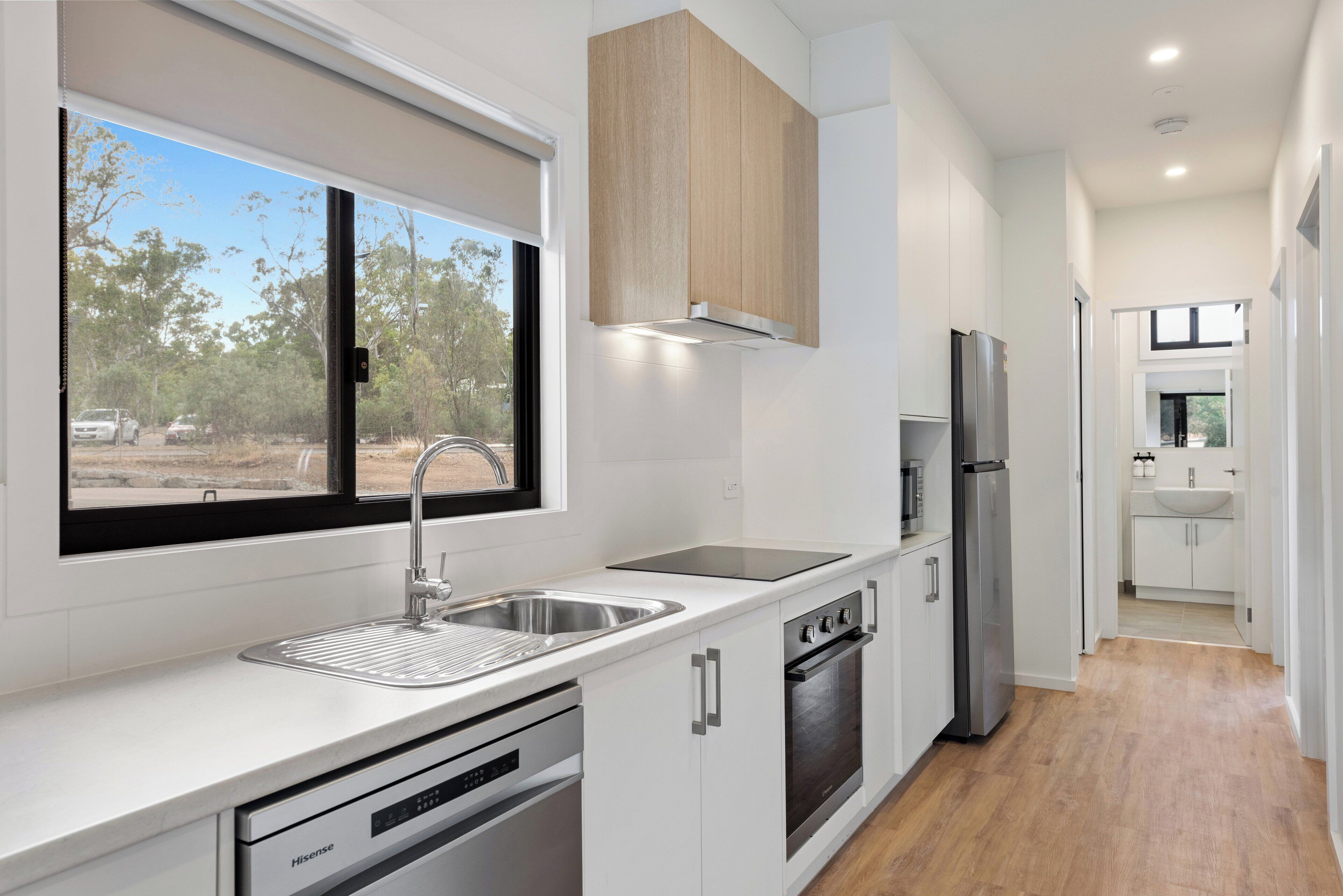 Una cocina moderna con un lavamanos de acero inoxidable, horno empotrado y refrigerador.