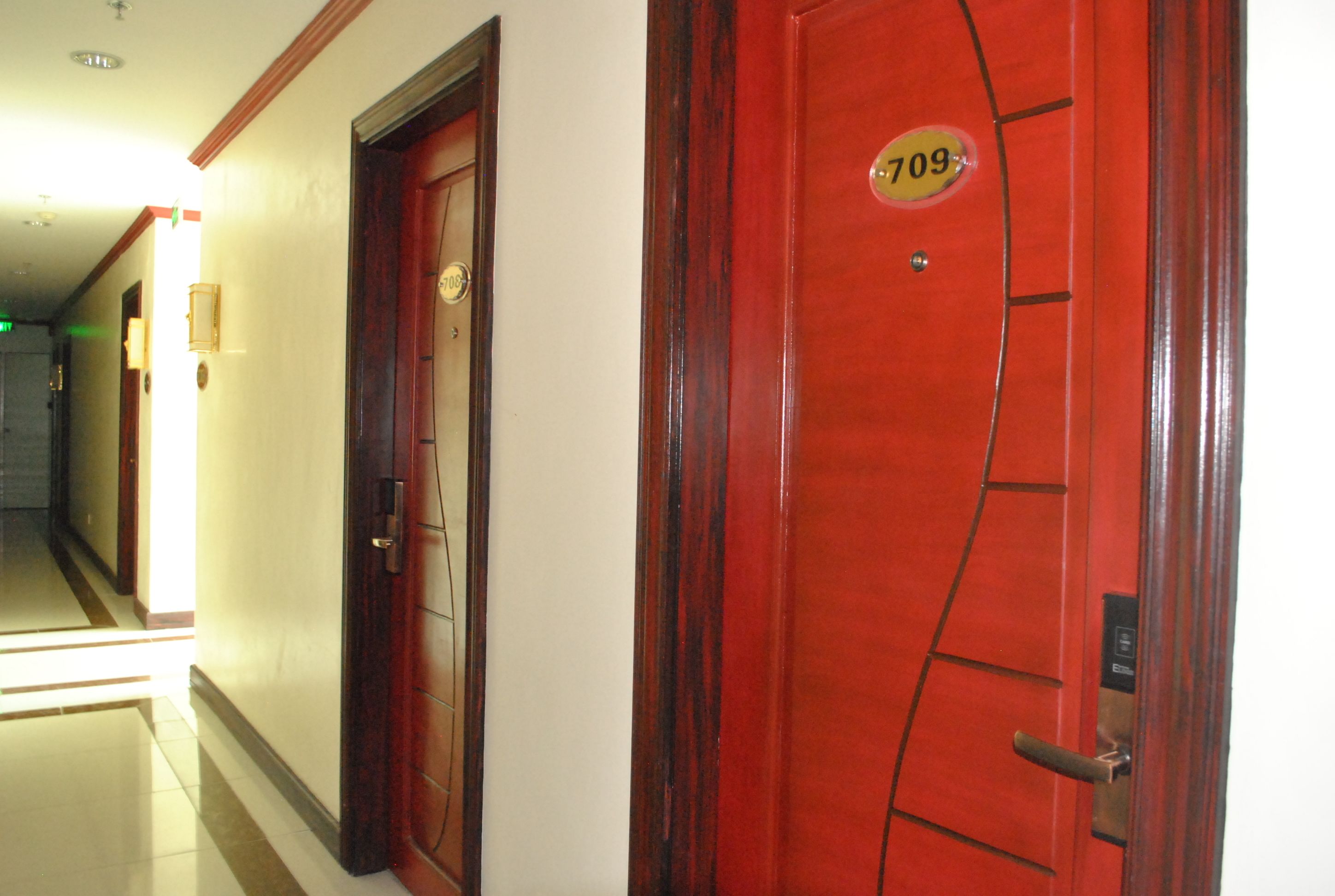 Pasillo de hotel con puertas de madera, una marcada con el número 709.