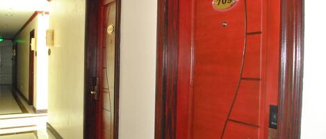 Pasillo de hotel con puertas de madera, una marcada con el número 709.
