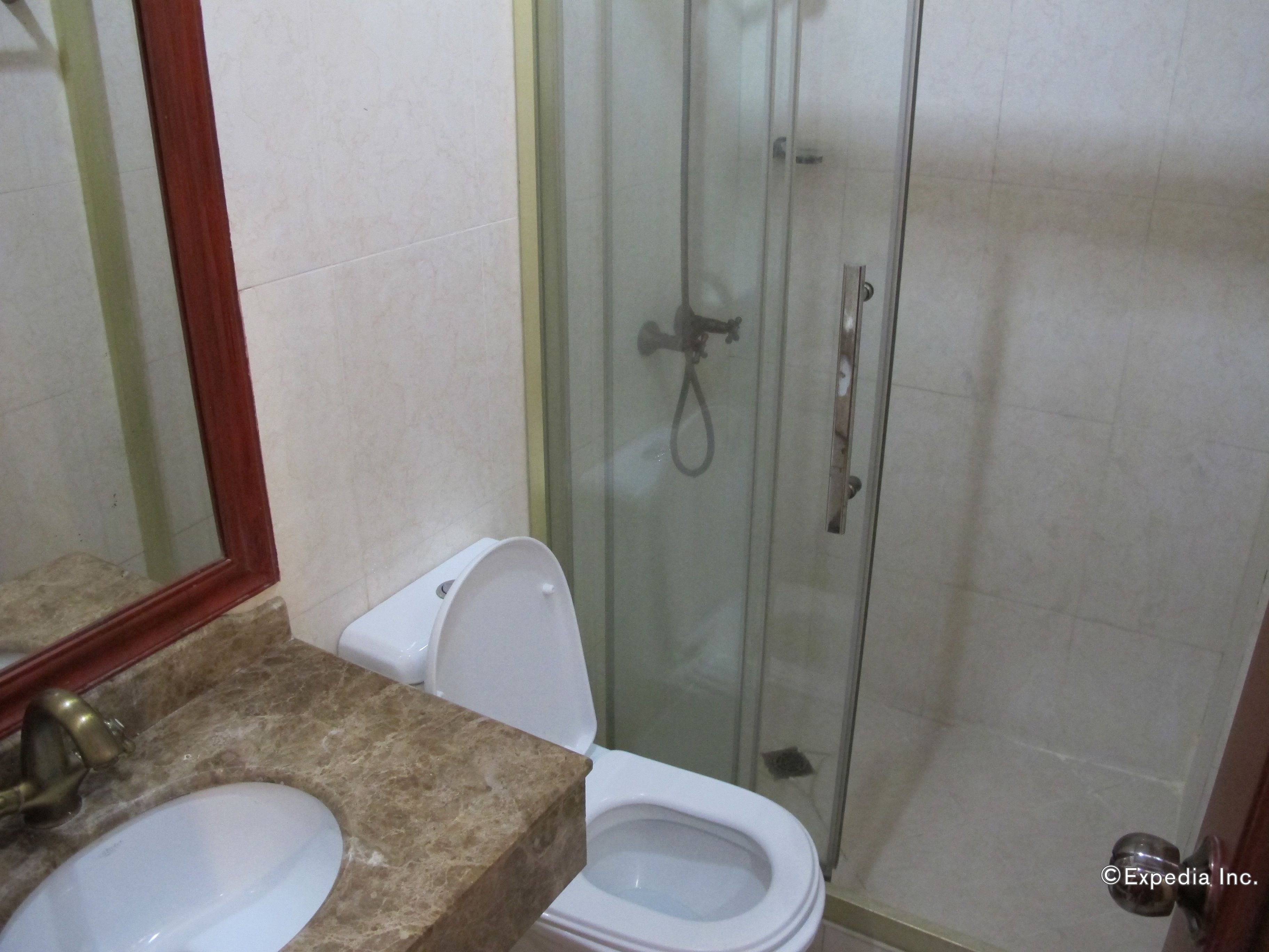 Une salle de bain avec un lavabo en marbre, des toilettes et une douche à parois de verre.