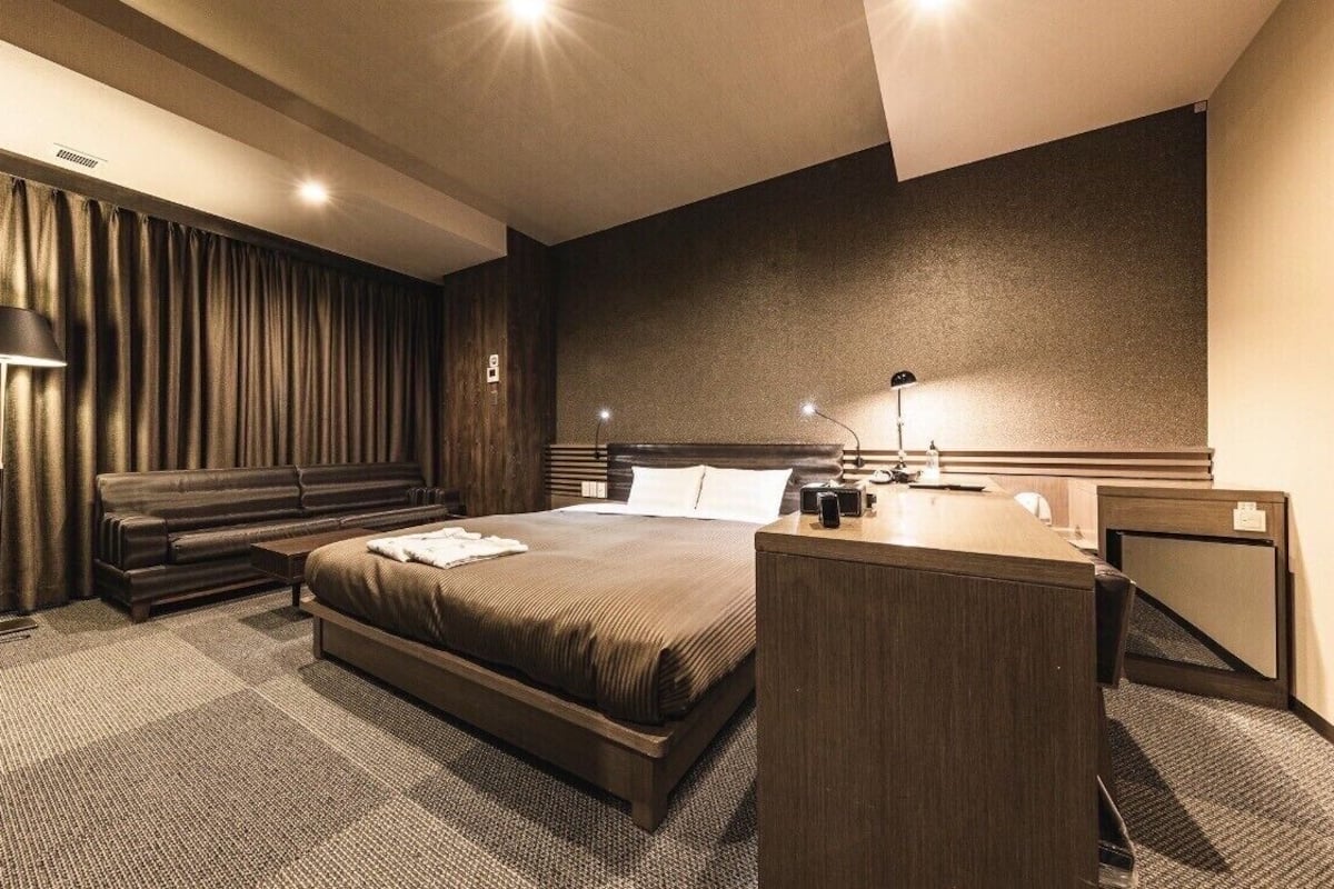 Une chambre d’hôtel moderne avec un grand lit, un bureau et un canapé.