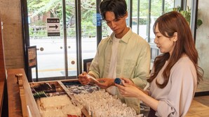 A person examining packaged food items at a counter with a window view of a street and a sign indicating a 'Do not use' direction. - Hotel Relief Sapporo Susukino (Sapporo)