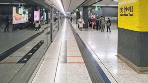A subway station with a lift sign, a digital information board, and a yellow wall with text. - Well Yet Guest House (Kowloon)