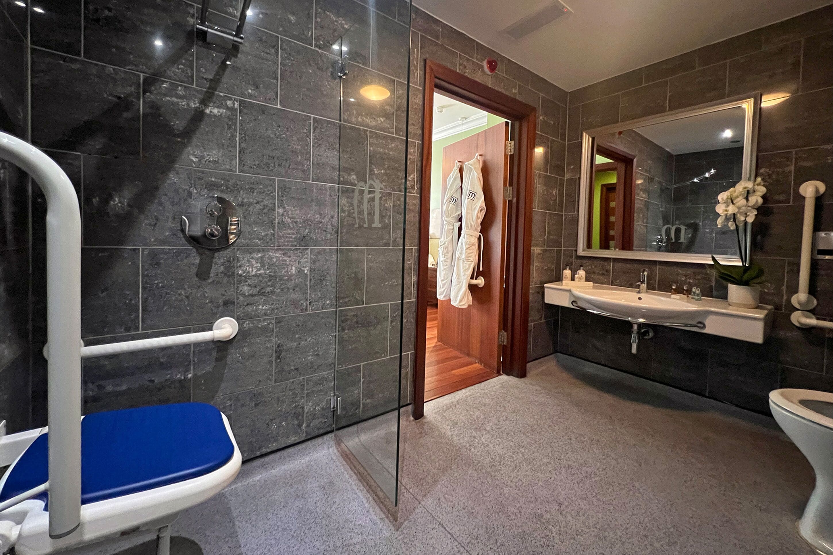 Un baño moderno con ducha, lavamanos e inodoro.