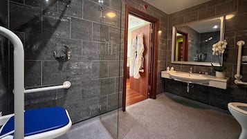 Un baño moderno con ducha, lavamanos e inodoro.