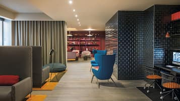 Relax in this stylish living room with a sofa, armchair, and desk, surrounded by a brick wall and large window.