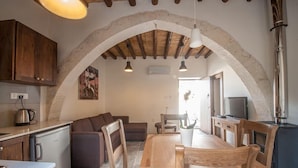 Una cocina acogedora con un arco de piedra, muebles de madera y una estufa moderna.