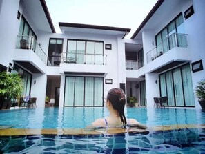 Un bâtiment moderne avec une piscine en premier plan.