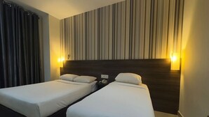 A hotel room with two single beds, a striped wall, and two wall-mounted lights. - My Hotel @ Sentral (Kuala Lumpur)