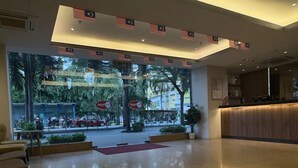 A spacious lobby with a reception desk, a red carpet, and a view of the street outside. - My Hotel @ Sentral (Kuala Lumpur)