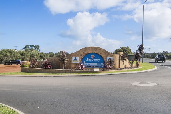 A Discovery Holiday Parks sign with a curved arch and a blue background.