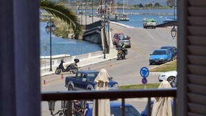 A view of a marina with boats, a bridge, and a road with cars and a motorcyclist. - Hotel Boschetto (Lefkada)