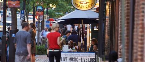 A busy street scene with a sign for 'Fish Market' and a live music and lobster sign.