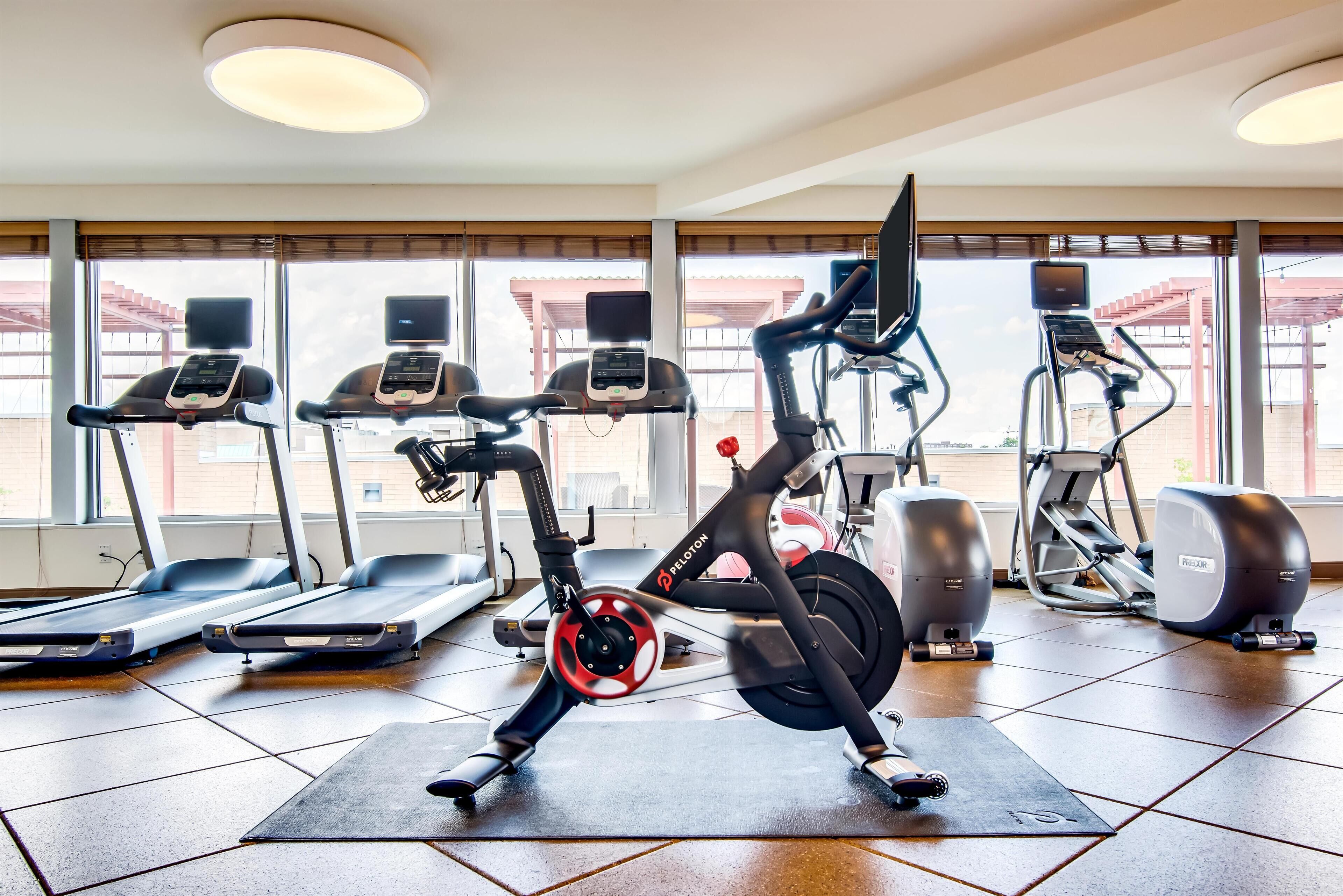 Un gimnasio con bicicletas estáticas, cintas de correr y elípticas.