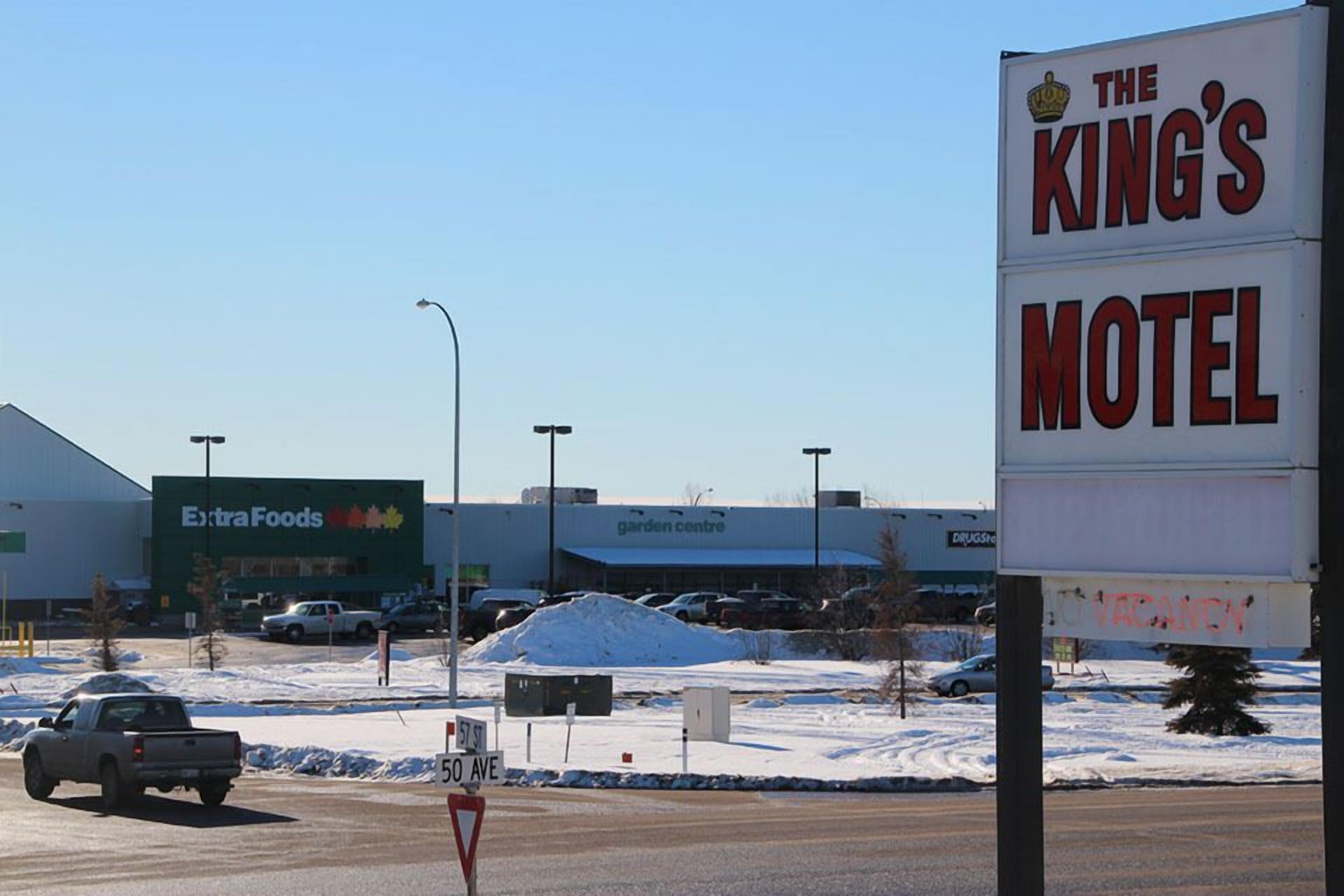 Et motel skilt med teksten "The King's Motel" og et skilt der viser "Værelser ledige".