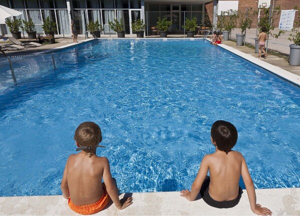 A swimming pool with two children sitting on the edge. - INOUT Hostel Barcelona (Barcelona)