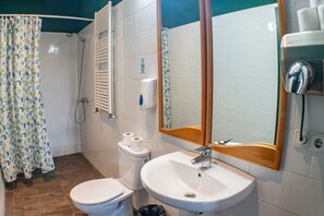 A bathroom with a shower, toilet, sink, and a mirror. - INOUT Hostel Barcelona (Barcelona)